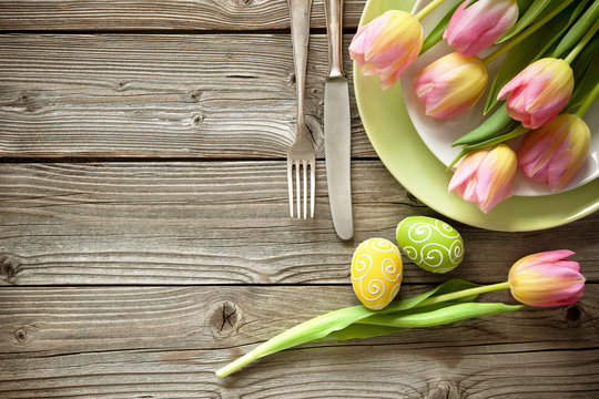 Easter table setting with spring tulips and cutlery