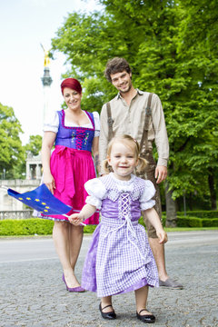 Girl waving European flag with parents in background