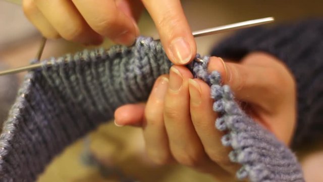 Knitting hands threads on spokes