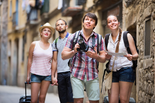Couples with baggage walking the city.