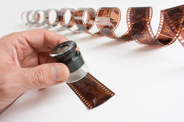 hand holding  magnifying glass and film