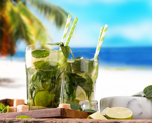Mojito lime drinks on wood with blur beach background