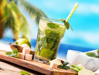 Mojito lime drinks on wood with blur beach background