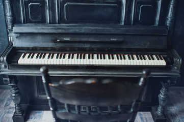 Fototapeta na wymiar Black antique piano and a chair. General form