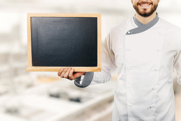chef cook holding blank blackboard in hand
