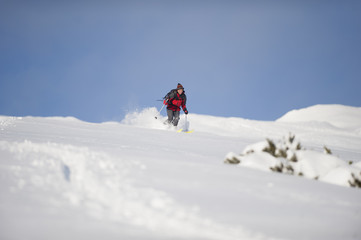 Naklejka na ściany i meble Skillful skier skiing downhill in nature on winter time.