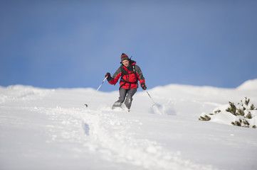 Fototapeta na wymiar Skier in action skiing. Mid adult man skiing down steep hill in beautiful nature.