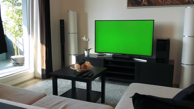 A TV with a green screen in a cozy living room