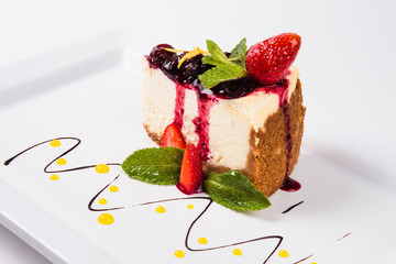 Cheesecake with jam garnished with strawberries and mint leaves 