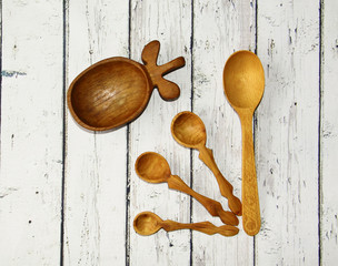 Wooden kitchen spoon and plate on the table, top view