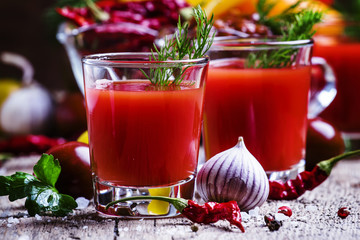 Spicy tomato juice with salt and spices, vintage wooden backgrou