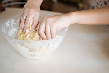 Woman kneads the dough for cooking home meals.