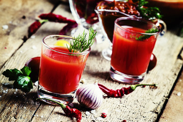 Spicy tomato juice with salt and spices, vintage wooden backgrou