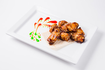 Fried chicken wings with sauce on a white plate