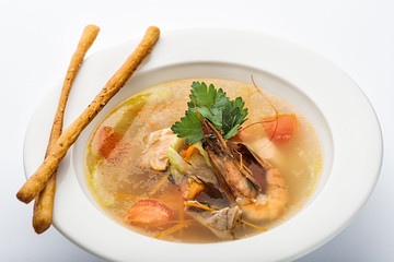 Soup with shrimp in a white plate.