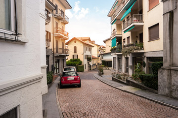 Road and town buildings. Cars parked in the street. Spend Summer in Italy.