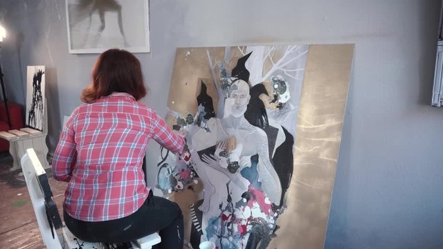 Female artist painting picture in studio
