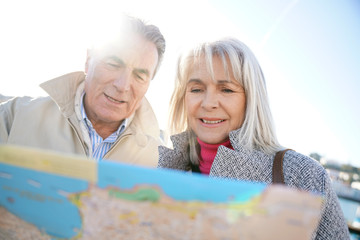 Senior couple in town looking at city map