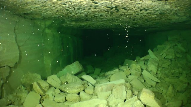 Half-buried by rubble stone corridors of a flooded mine.

