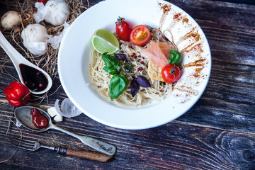Italian food. Pasta penne with salmon, sauce, basil and garnish