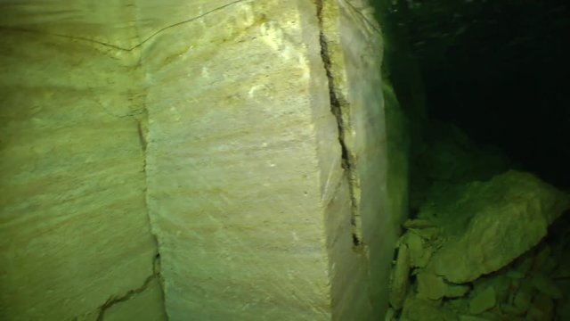 Cracks on the walls of the tunnel in flooded mine for the extraction of building stone.

