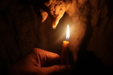Lighting candles on hand in the limestone caves. 