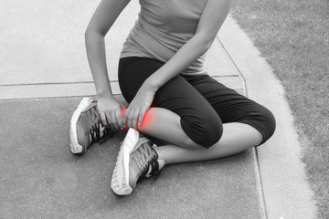 Sporty woman ankle sprain while jogging or running at park