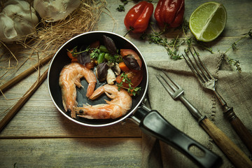 Romantic dish: prawns with colorful bell peppers, vegetables, basil, tomatoes in pan with sauce in St Valentines day