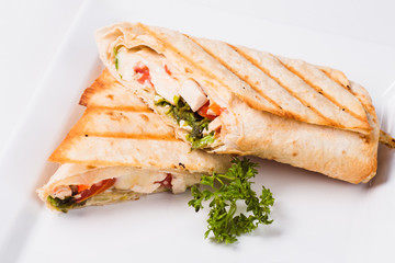 Tasty fresh wrap sandwich with chicken, vegetables and sauce (close up)