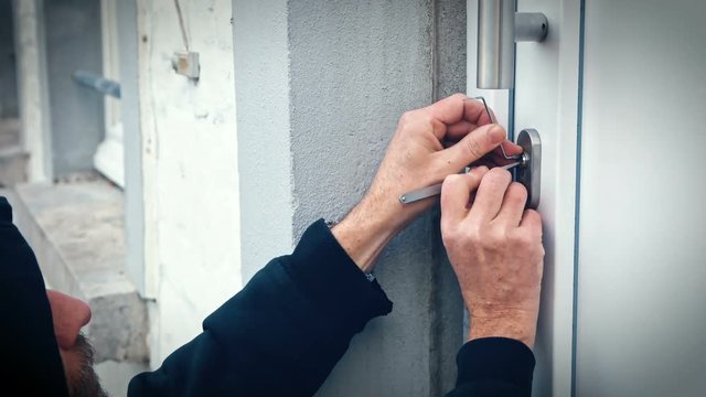 Einbrecher &ouml;ffnet Haust&uuml;re mit Lock picking Werkzeug