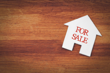 house for sale symbol with wood background