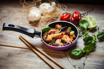 Romantic dish: prawns with colorful bell peppers, vegetables, basil, tomatoes in pan with sauce in St Valentines day