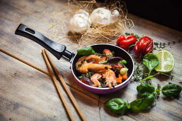 Romantic dish: prawns with colorful bell peppers, vegetables, basil, tomatoes in pan with sauce in St Valentines day