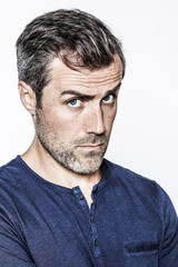 critical middle aged handsome bearded man looking with doubt