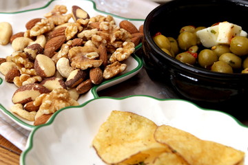 Olives, feta cheese, crisps, walnuts, almonds, cashew nuts, brazil nuts and hazelnuts served with an aperitif