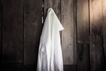 white shirt of women hanging on wooden wall