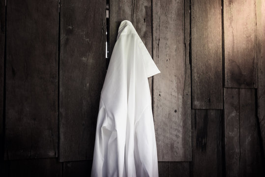 White Shirt Of Women Hanging On Wooden Wall