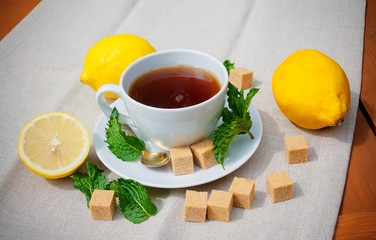 Tea with mint, brown sugar and lemon on  table