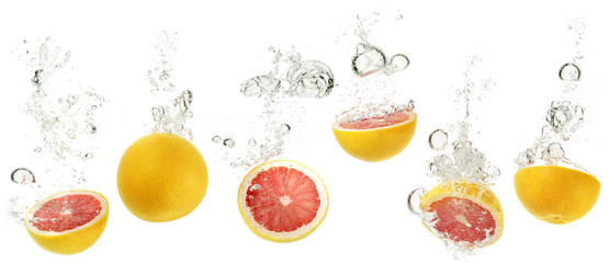 set of grapefruits dropping into water on white background