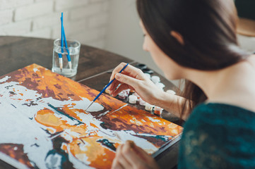 girl in a blue dress draws picture paints