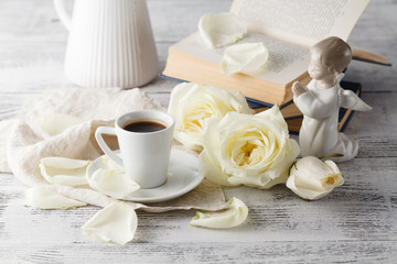 cup of coffee with roses on the wooden background