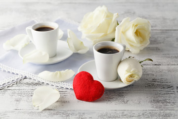 Two cups and felt hearts on light background