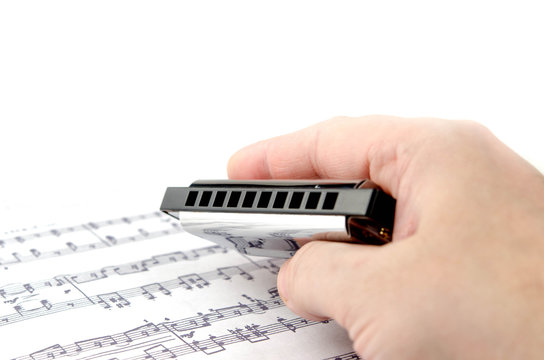Silver harmonica in hand