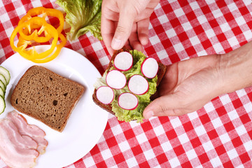 Man cooking sandwich with black bread and bakon in the kitchen. Vegetables, bacon and bread
