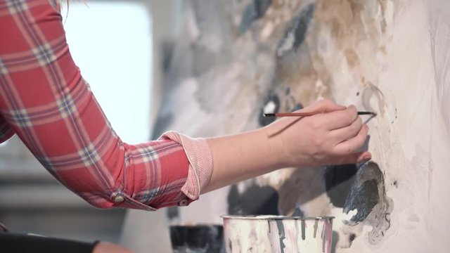 Female artist painting picture in studio