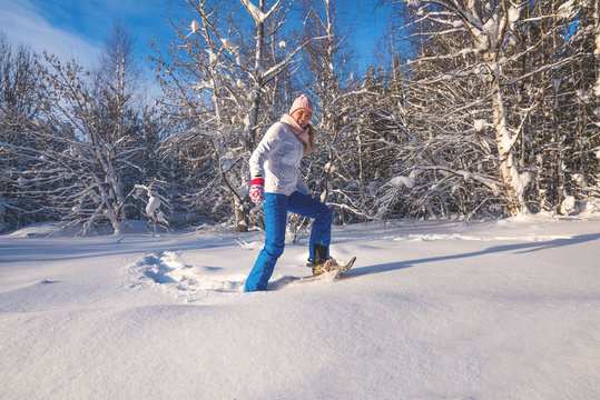 Winter sport activity. Woman with snowshoes on fluffy snow in fo