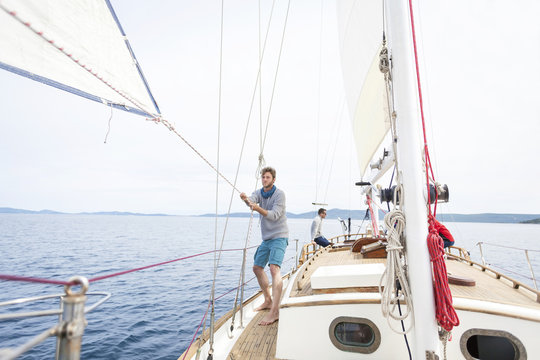 Man pulling on rope on sailboat