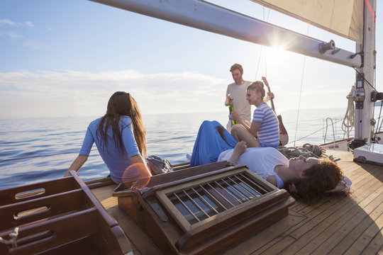 Friends relaxing on boat deck of sailboat