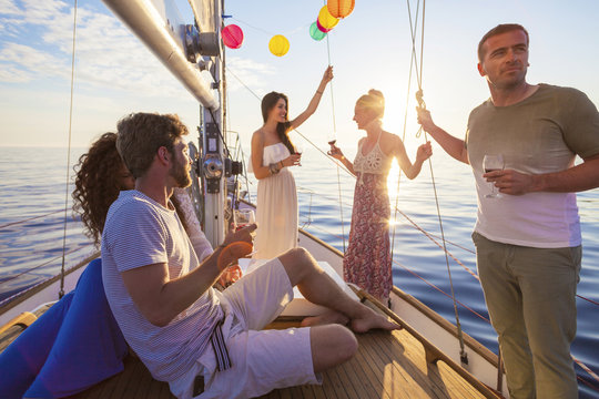 Friends celebrating with wine on sailboat