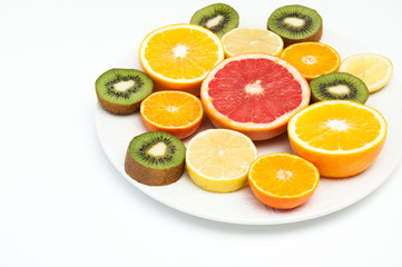 Citrus fruits on a platter, cut on a table on a white background